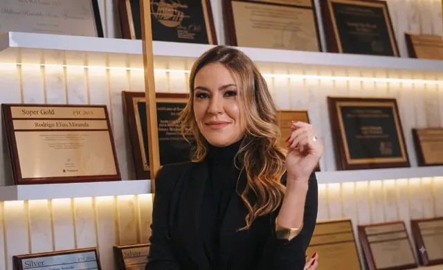 Débora Resende entre placas de premiação